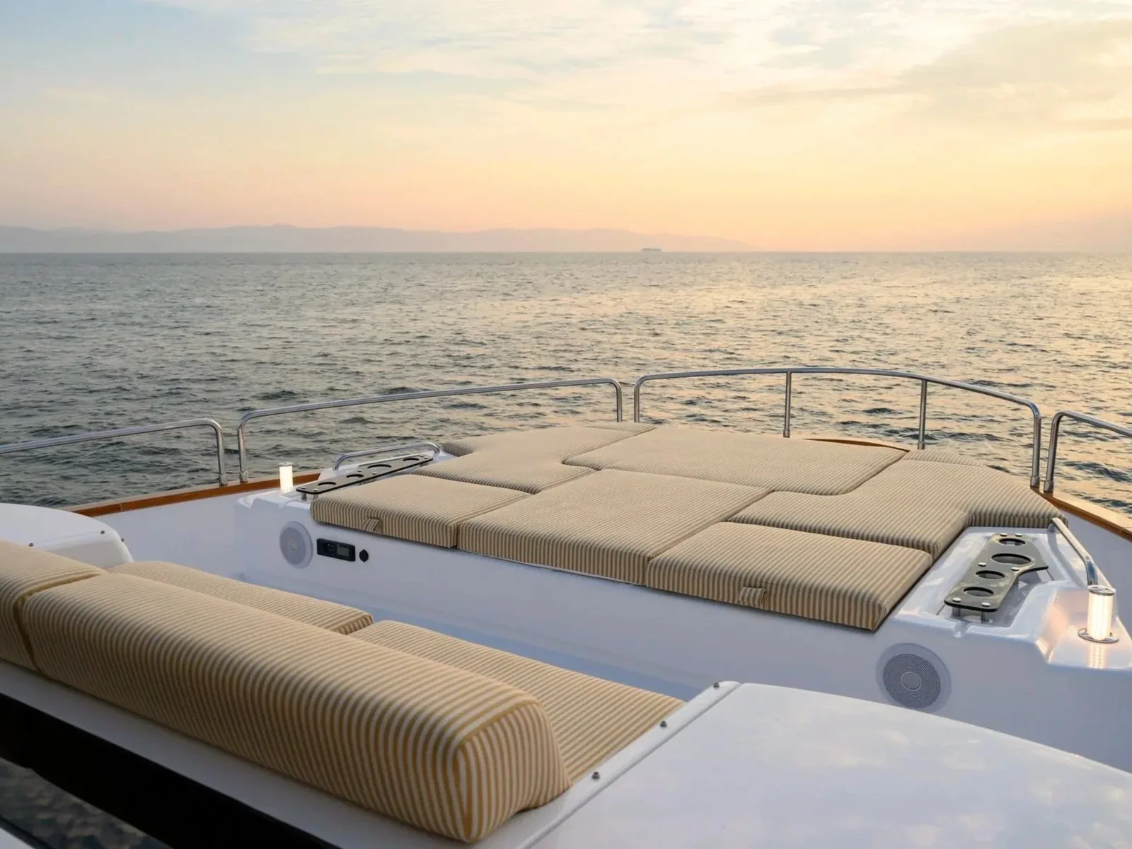 The day yacht&rsquo;s cushioned sun-pad bow, anchored on a calm sea