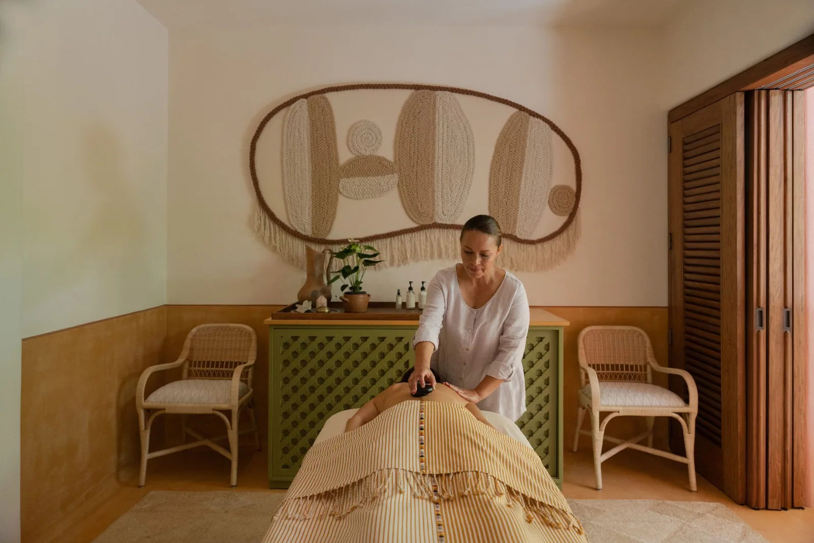 A therapist preparing the treatment bed in one of the spa suites