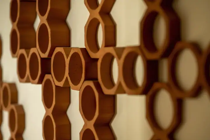 A detail of a carved wooden ring installation on an interior wall