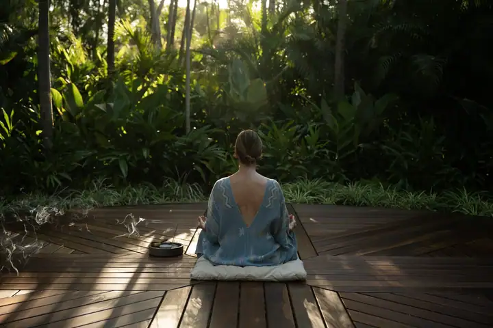 A guest meditating alone on the jungle yoga and meditation deck