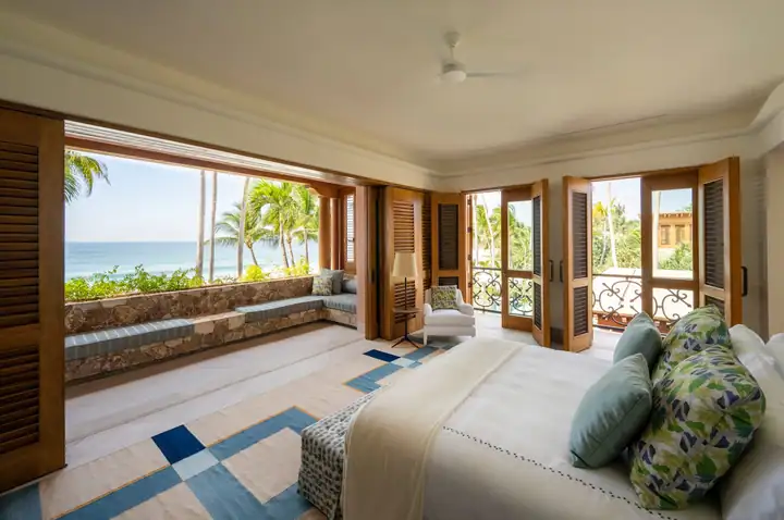 An ocean-view king suite with louvred shutters folded back to the Pacific